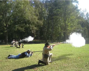  ?? Staff photo by Greg Bischof ?? ■ Confederat­e soldiers attempt to thwart a Union Army advance during a Civil War re-enactment Sunday at the Old Washington State Historic Park. The event marked the 28th annual Civil War Weekend since re-enactments began in 1991.