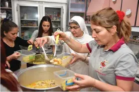  ?? ?? Ukraine: Preparing food supplied by ACN for displaced mothers and children