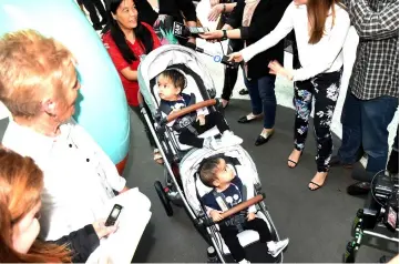  ??  ?? Nima, Dawa and Zangmo are surrounded by media as they leave the Royal Children’s Hospital with their mother. — AFP photo