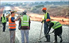  ?? ZHOU XIAOXIONG / XINHUA ?? Workers from China and Africa work on a highway project in Kenya. Constructe­d by a Chinese company, the 130-km highway opened in September 2016.