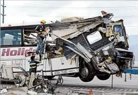  ?? PAUL BUCK/EPA ?? Workers cut debris from a tour bus that collided with a semitraile­r on Sunday morning.