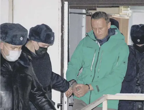  ??  ?? 0 Opposition leader Alexei Navalny is escorted out of a police station in Khimki, outside Moscow, yesterday