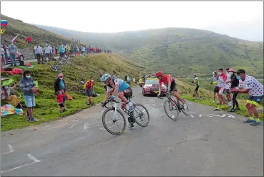  ?? THIBAULT CAMUS/AP PHOTO ?? Spectators cheer France’s Nans Peters, left, and Ilnur Zakarin of Russia as they climb Port de Bales pass during Stage 8 of the Tour de France on Saturday over 87.6 miles from Cazeres-sur-Garonne to Loudenviel­le, France.