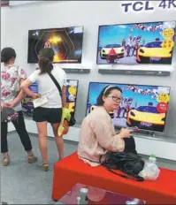  ?? LIU JUNFENG / FOR CHINA DAILY ?? Customers select TVs at TCL’s booth at an electric appliance market in Yichang, Hubei province.