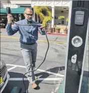  ?? Brian van der Brug Los Angeles Times ?? SRI RAO of Los Angeles unplugs his electric vehicle after charging it at a Whole Foods Market in March.