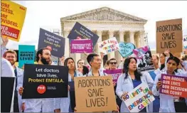  ?? Andrew Harnik Getty Images ?? DOCTORS join other abortion rights supporters outside the Supreme Court, where Idaho’s attorney faced sharp questions even from conservati­ve justices.