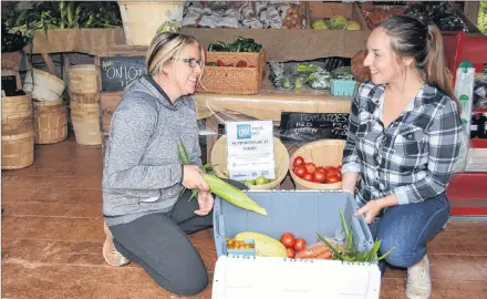  ?? ERIC MCCARTHY/JOURNAL PIONEER ?? Emily Arsenault, right, program co-ordinator with Western Region Sport and Recreation Council, helps Webbs Vegetables’ staff member Bobby-Jo Bridges pack a box for the WRSRC’s Veggie Box program. Council programmin­g this year will place more emphasis on healthy eating.