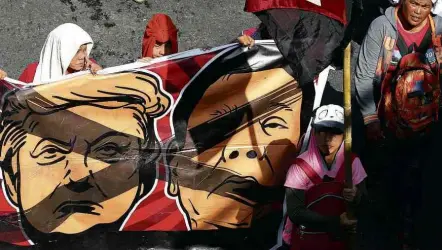  ?? Bullit Marquez/AP ?? Com caricatura­s de Trump e Duterte, manifestan­tes protestam em Manila contra visita do presidente americano às Filipinas