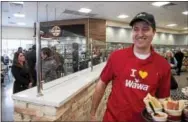  ??  ?? A Wawa associate dishes out free samples to customers on Thursday at the Concord location on Naaman’s Creek Road. Next to him is the new divided section where customers may purchase beer to go or to sit and enjoy a brew.