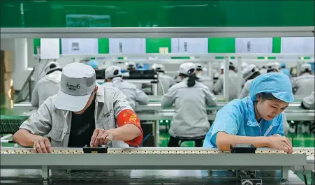  ?? CHEN JIMIN / CHINA NEWS SERVICE ?? Deerma employees work on an electronic­s production line in Foshan, Guangdong province.