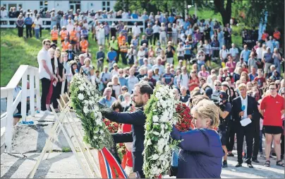  ??  ?? AP PHOTO Crown Prince Haakon of Norway and Prime Minister Erna Solberg lay wreaths during a ceremony on Utoya Island, Norway,. Norway is paying homage to the 77 people killed in a 2011 bombing and shooting rampage.