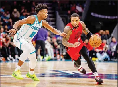  ?? ?? Charlotte Hornets guard Dennis Smith Jr. (8) guards Portland Trail Blazers guard Damian Lillard (0) during the second half of an NBA basketball game in Charlotte, N.C. (AP)