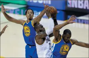  ?? AP PHOTO/TONY DEJAK ?? Cleveland Cavaliers forward LeBron James (23) drives between Golden State Warriors' Shaun Livingston (34) and Andre Iguodala (9) during the second half of Game 3 of basketball's NBA Finals in Cleveland, Wednesday.