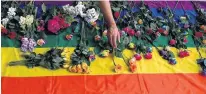  ?? REUTERS ?? Campaigner­s place flowers on a multicolou­red flag as they protest for LGBT rights in Chechnya outside the Russian embassy in London, in a file photo.