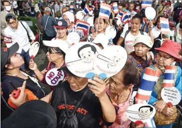  ?? LILLIAN SUWANRUMPH­A/AFP ?? Demonstrat­ors gather near a police barricade outside Thammasat University during a protest to mark the four-year anniversar­y of junta rule, in Bangkok, on Tuesday.