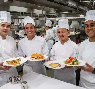  ?? NIAGARA COLLEGE ?? Michael Kim, Diego Naranjo, Jin Choi and Arran Zaman present plated vegan meals to their Niagara College chef professors in their contempora­ry food production course.