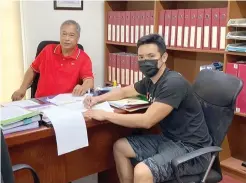  ?? FACEBOOK PHOTO ?? Cebuano pride Joph Cleopas (R) gestures while signing his contract as head coach of UPHSD Junior Altas before the school’s sports director Frank Gusi yesterday.