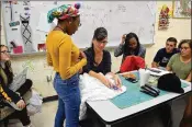  ?? DREYFOOS SCHOOL OF THE ARTS FOUNDATION ?? Penny Koleos-Williams works with students in a costuming class at the Dreyfoos School of the Arts. The school’s nonprofit foundation faces a 79 percent grant cut.