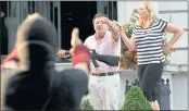  ?? LAURIE SKRIVAN — ST. LOUIS POST-DISPATCH ?? Armed homeowners Mark and Patricia McCloskey, standing in front their house along Portland Place in the Central West End of St. Louis, confront protesters marching to St. Louis Mayor Lyda Krewson’s house.