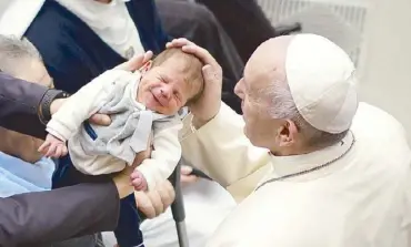  ?? AP ?? Pope Francis blesses a baby during a mass at the Vatican on Saturday.