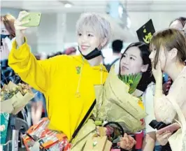  ?? — IC ?? Luo Zhiyi (left), a participan­t in the reality show “Produce 101,” takes a selfie with her fans upon arrival in Beijing for the contest final.