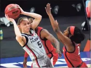  ?? Eric Gay / Associated Press ?? UConn guard Paige Bueckers (5) passes the ball over Arizona guard Aari McDonald during the first half of a semifinal in the NCAA women’s Final Four on April 2 at the Alamodome in San Antonio.