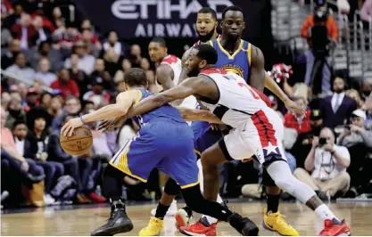  ?? — AFP ?? WASHINGTON: Stephen Curry #30 of the Golden State Warriors dribbles around John Wall #2 of the Washington Wizards in the second half at Verizon Center on Tuesday, in Washington.