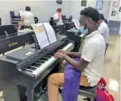  ?? COURTESY PHOTO BY KATHERON LATHAM ?? Junior basketball player Tongun Gore practices during piano class at Central High School.