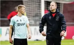  ??  ?? AMSTERDAM: Ajax’s Dutch midfielder Daley Sinkgraven (L) and assistant manager Dennis Bergkamp speak during a training session. — AFP