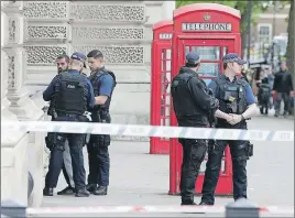  ?? AP PHOTO ?? Police officers talk to a man at the scene after a person was arrested following an incident in Whitehall in London. London police arrested a man for possession of weapons Thursday near Britain’s Houses of Parliament.