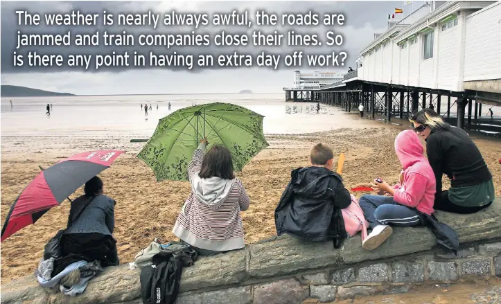  ??  ?? FUN OR FUTILE? Brollies up, coats on, storm clouds loom - it’s a typical Easter Bank Holiday scene that brings out the true British spirit in millions of families across the rain-soaked land