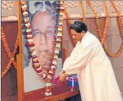  ?? ?? BSP supremo Mayawati pays floral tributes to the portrait of party founder Kanshi Ram on his 88th birth anniversar­y at the party office in Lucknow on Tuesday.