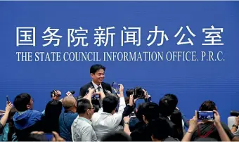  ?? AP ?? Yang Guang, spokesman of the Hong Kong and Macau Affairs Office of the State Council, is approached by reporters as he prepares to leave after a press conference about the ongoing protests in Hong Kong.