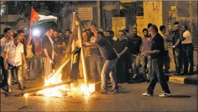  ?? AP/MAHMOUD ILLEAN ?? Palestinia­ns burn mock metal detectors during a demonstrat­ion Sunday in Bethlehem.