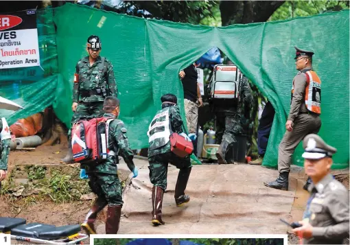  ?? PHOTOS AFP ?? 1. Des ambulancie­rs militaires pénètrent dans le périmètre de sécurité établi à l’entrée de la grotte située dans le nord du pays. 2. À Chiang Rai, les jeunes rescapés étaient attendus par une foule de curieux qui ont applaudi au passage des...