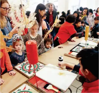  ??  ?? February 16, 2018: Children watch an artist make sugar paintings at the event “Chinese New Year Students’ Day” held in the Lincoln Center, New York. by Wang Ying/xinhua