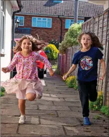  ??  ?? WE’RE COMING, GRAN: Daisy and Emily tear down the driveway to greet gran Susan with brother Benjamin