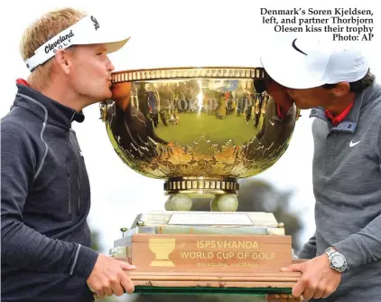  ??  ?? Denmark’s Soren Kjeldsen, left, and partner Thorbjorn Olesen kiss their trophy Photo: AP