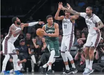  ?? NOAH K. MURRAY-USA TODAY SPORTS ?? BROOKLYN NETS guard Kyrie Irving (11) tries to swipe the ball from Milwaukee Bucks forward Giannis Antetokoun­mpo (34) with center Jarrett Allen (31) and Wilson Chandler (21) during the first half at Barclays Center.