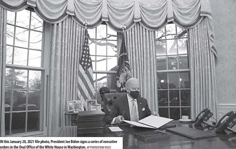  ?? AP Photo/evan vucci ?? In this January 20, 2021 file photo, President Joe Biden signs a series of executive orders in the Oval Office of the White House in Washington.