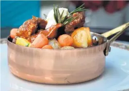  ?? CARLINE JEAN/SUN SENTINEL ?? Moroccan lamb ragu is served in a copper pot at Grapes Wine Cafe and Market in Fort Lauderdale.