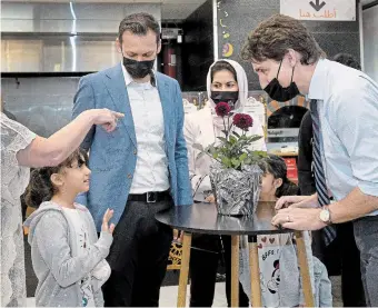  ?? CATHIE COWARD THE HAMILTON SPECTATOR ?? Prime Minister Justin Trudeau talks to eight-year-old Atresa and her family — dad Mirwaise, and mom, Zuhal, as well as Atresa's younger sister Zoya, 6, and little brother Haris, who is 20 months and not pictured. Trudeau met with Afghan families new to Canada and living in Hamilton at Eastern Food Market on Upper Wentworth Street on Friday morning.