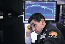  ?? Spencer Platt / Getty Images ?? A trader working on the floor of the New York Stock Exchange watches as the Dow Jones average plummets 4.6 percent.