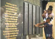  ?? Andrew Craft / Associated Press ?? Sgt. La David Johnson's wife, Myeshia, and her daughter touch his name plate at Fort Bragg, N.C.