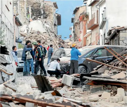  ?? PHOTOS: REUTERS ?? People stand along a road following a quake in Amatrice, central Italy.