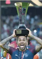  ?? — AFP ?? PSG’s Dani Alves holds the trophy as he celebrates with teammates after winning the French Trophy of Champions match against Monaco.
