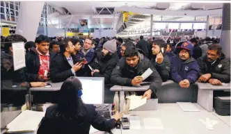  ?? REUTERSPIX ?? Passengers surround a customer service desk for Air India following delays in the departure area of Terminal Four at John F. Kennedy Internatio­nal Airport in New York City on Sunday.