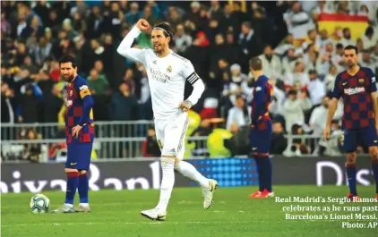  ??  ?? Real Madrid’s Sergio Ramos celebrates as he runs past Barcelona’s Lionel Messi. Photo: AP