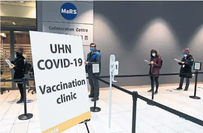  ?? NATHAN DENETTE THE CANADIAN PRESS ?? Health- care workers wait in line at a UHN COVID- 19 vaccine clinic in Toronto on Thursday.