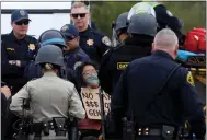  ?? ARIC CRABB — STAFF PHOTOGRAPH­ER ?? A protester is carried away by police officers after she and others shut down traffic along northbound Interstate 880.